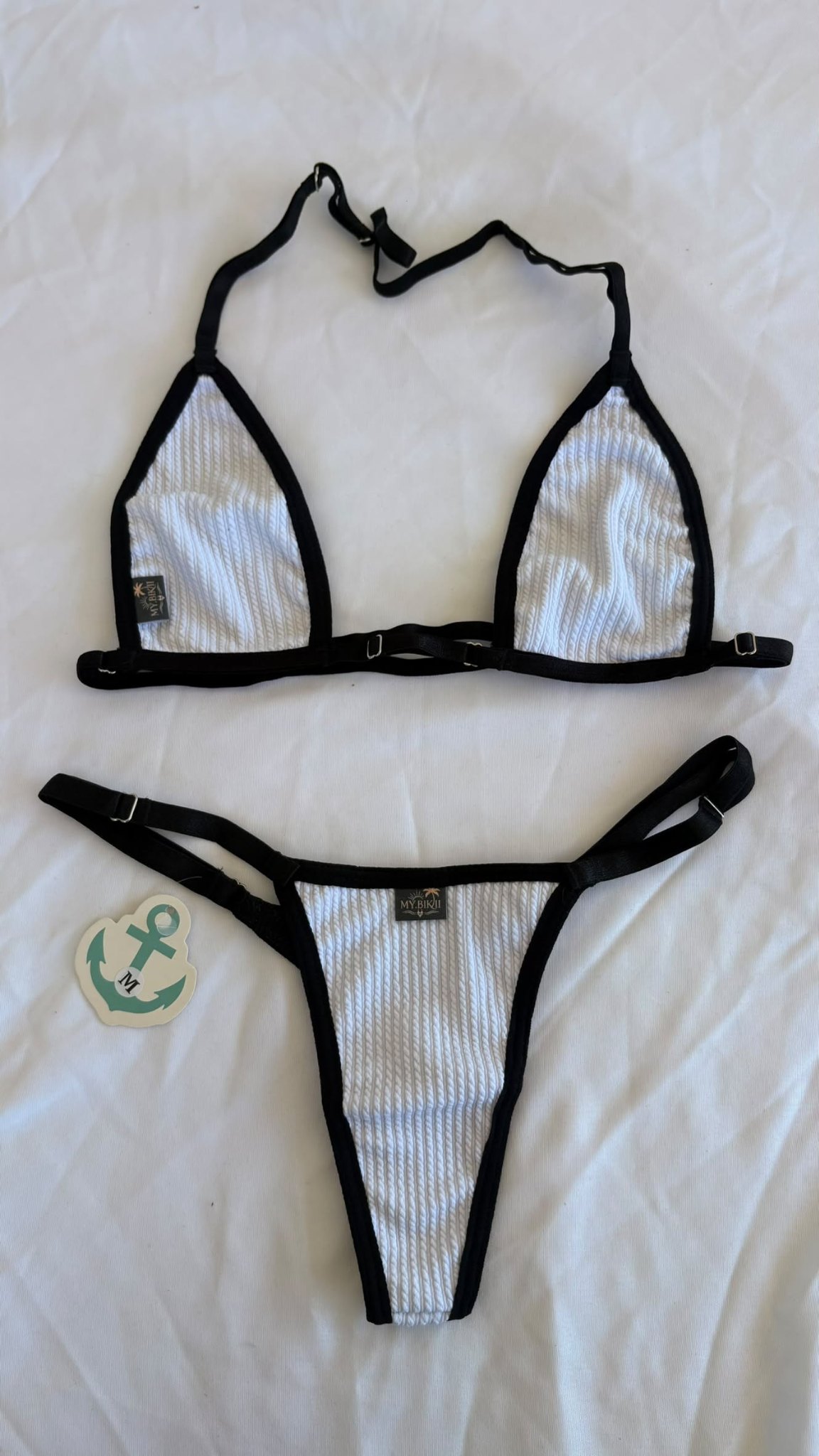 Ensemble bikini blanc texturé avec liserés noirs, haut triangle et bas assorti.