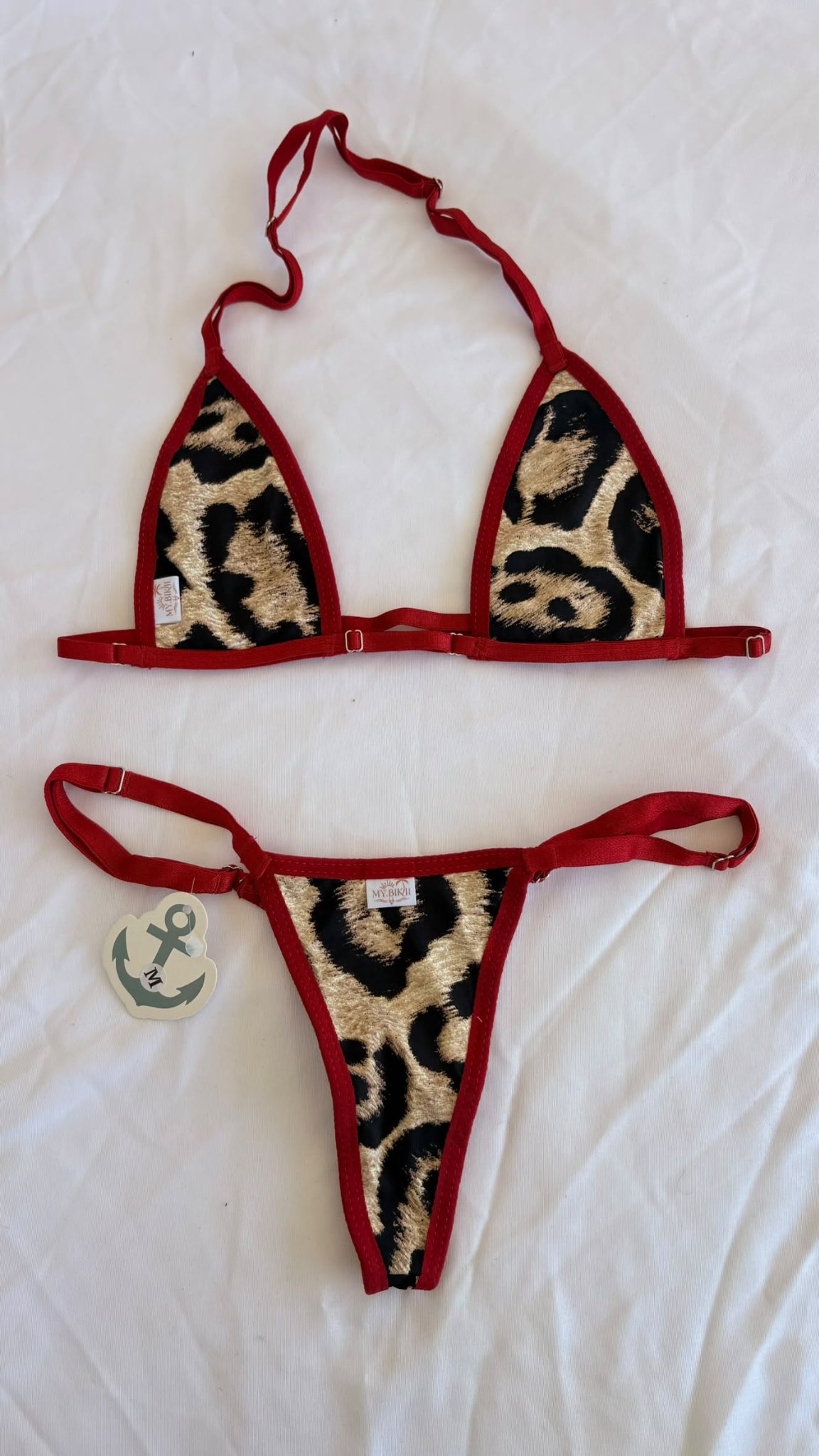 Ensemble bikini à imprimé léopard avec liserés rouges, haut triangle et bas assorti.