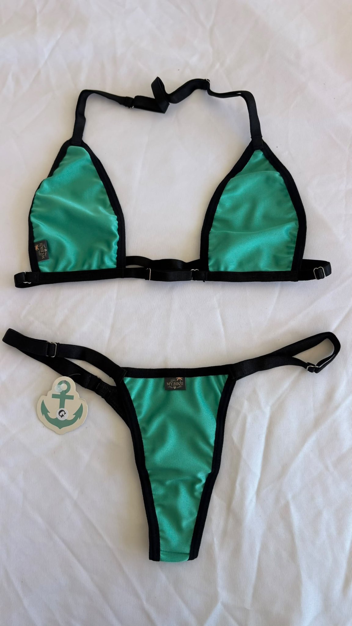 Ensemble bikini vert turquoise avec liserés noirs, haut triangle et bas assorti.